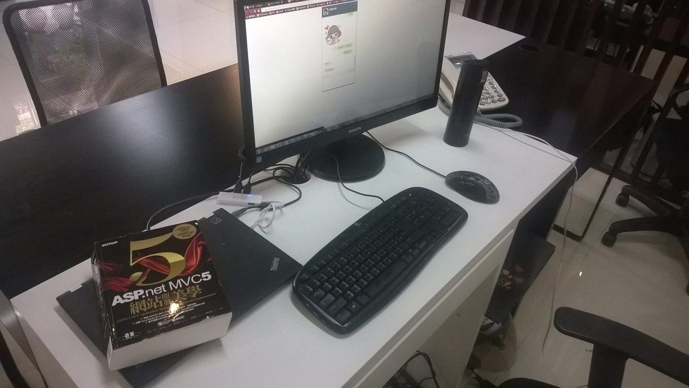 2015 年采霆第一間辦公室的工作桌，桌上放著一本 ASP.NET MVC5 開發書